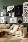 Black and white Christmas wall art set of 14 displayed as a festive gallery wall above a cream sofa against a green living room wall
