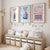 Three framed nautical-themed nursery wall art prints hang above a light wood storage bench with white bins in a styled children's room. The prints feature a lighthouse, a sailboat, and a motivational quote about waves, with a giraffe figure on the left