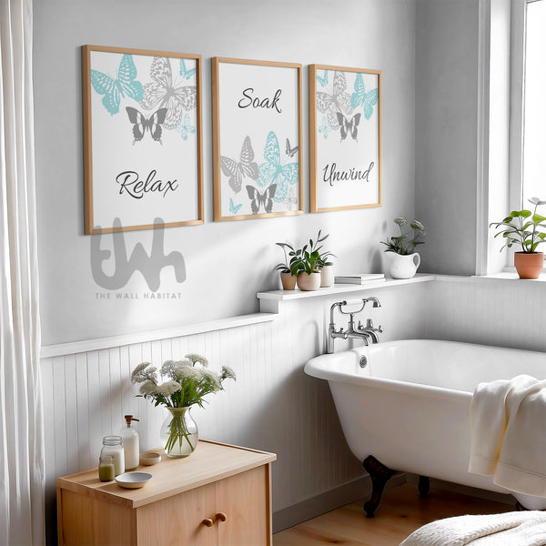 Set of 3 bathroom wall art prints in light teal and grey featuring butterflies and the words "Relax", "Soak", and "Unwind" – perfect spa-inspired decor for a calming, minimalist bathroom or home spa.