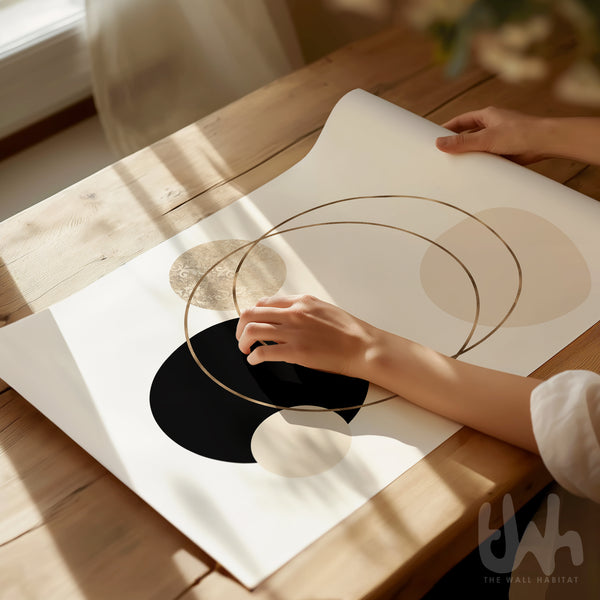 Person holding a piece of paper with abstract art on a wooden table