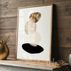Framed abstract art print on a wooden shelf with decorative items.