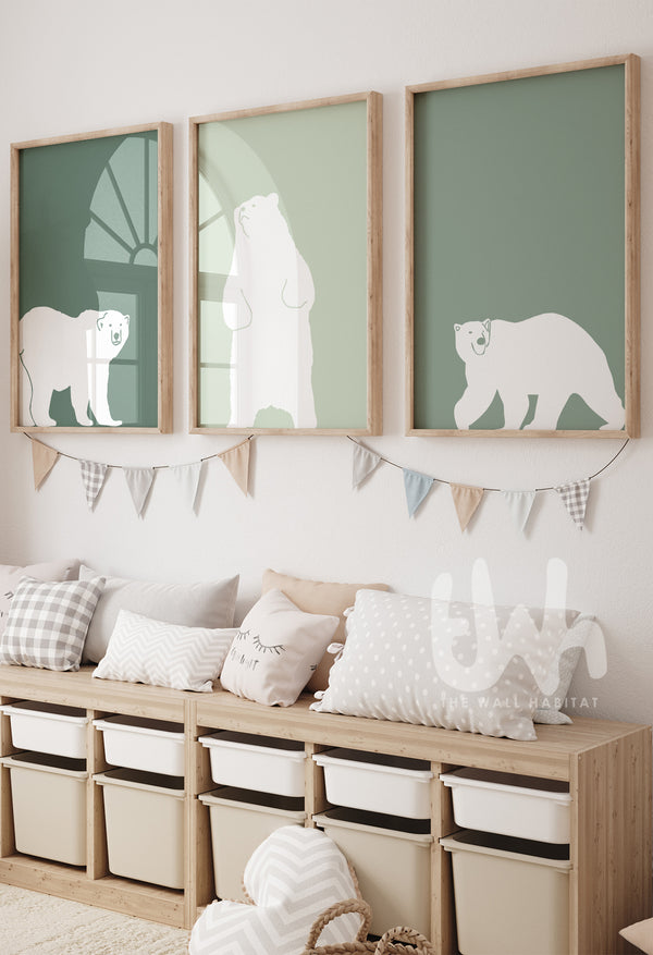 Set of three framed sage green polar bear wall art prints hanging above a toy storage bench in a neutral kids’ room