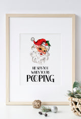 Vintage Santa Christmas bathroom poster with funny toilet quote displayed in a rustic gold wooden frame