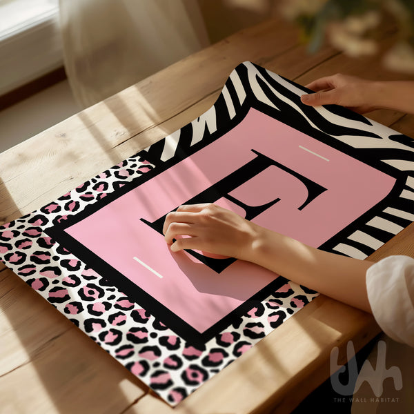 Personalised pink leopard initial wall art with zebra print border displayed in a modern interior setting