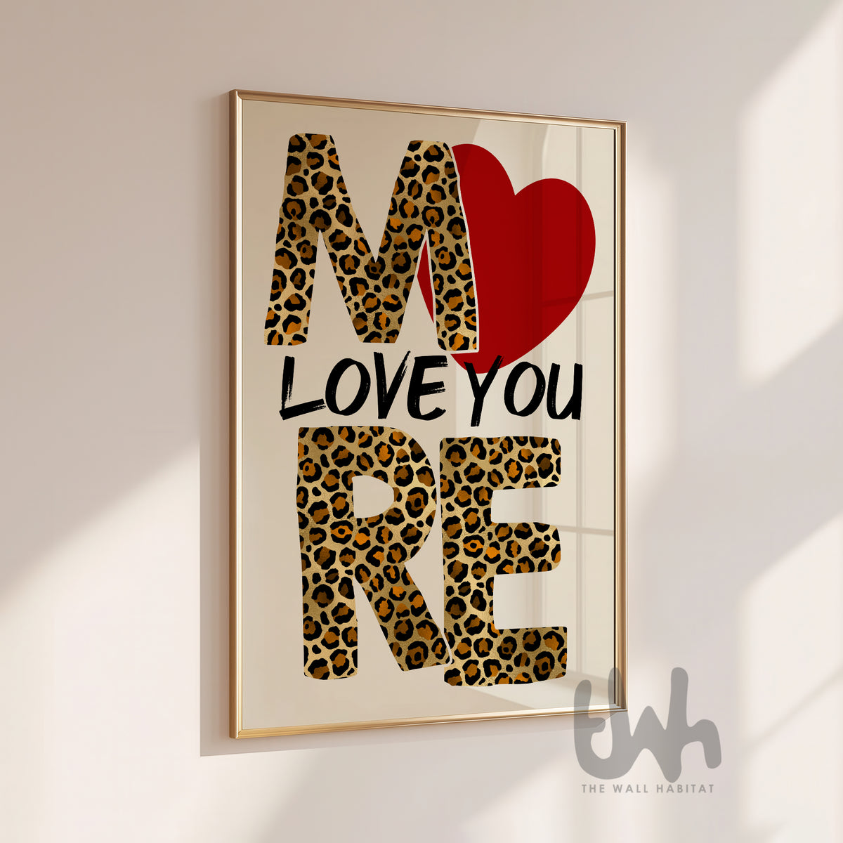 Framed artwork with 'I love you more' text in leopard print and red heart on a light background