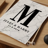 Marble wall art print with a bold black letter 'M', the names 'Jules & Harry', and the date '14.2.2018' printed below, styled on a wooden tray