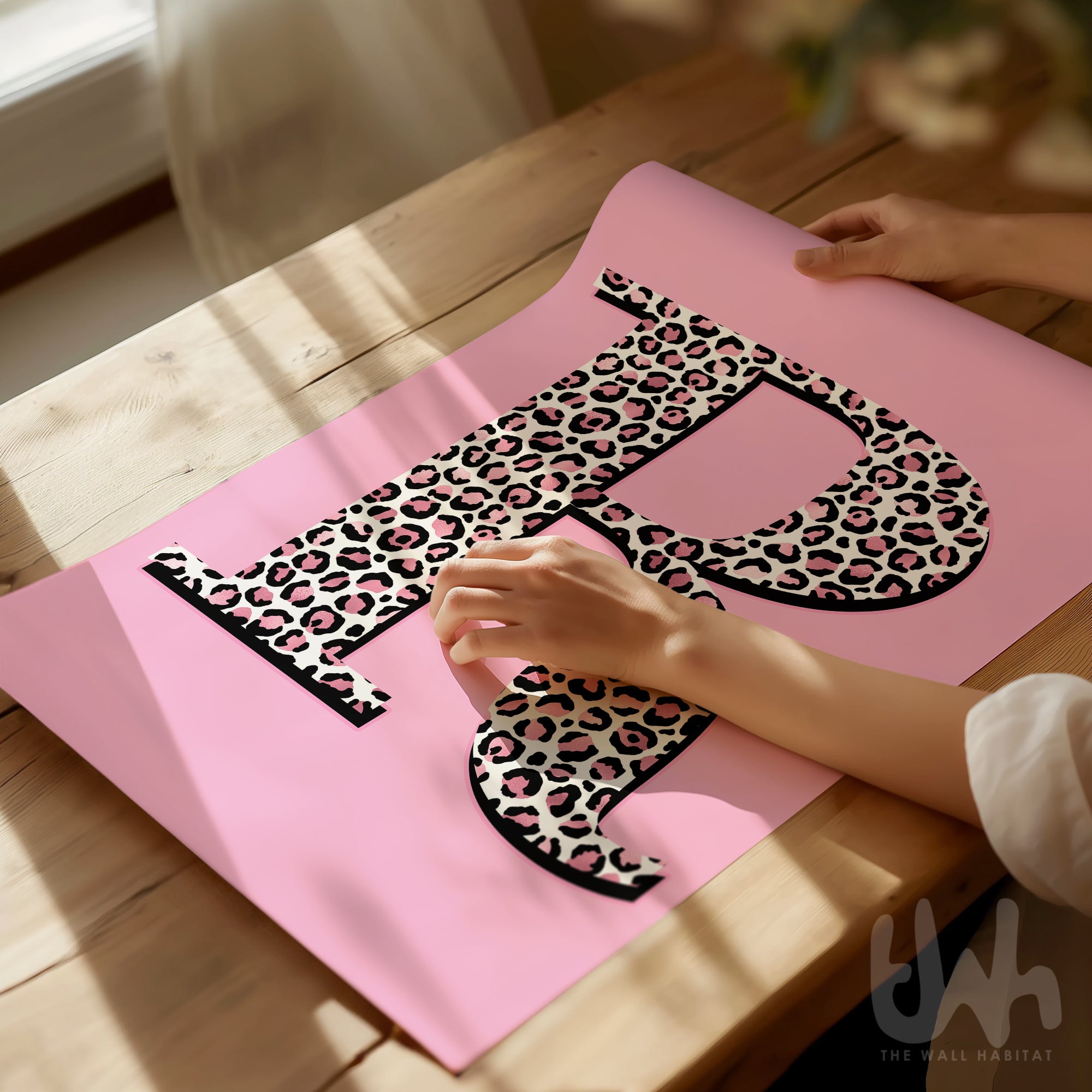 Personalised leopard print initial wall art with pink background displayed in a modern interior