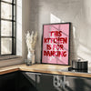 Modern kitchen with a framed poster saying 'This kitchen is for dancing' on a wooden countertop.