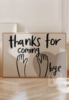 Neutral wall art print with black hand-lettered text reading 'Thanks for coming, bye' and waving hand illustrations over a taupe heart background