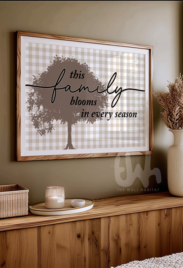 Decorative wall art with a tree and text on a plaid background, displayed on a wooden shelf.