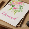 Floral design with the word 'Unwind' on a wooden surface