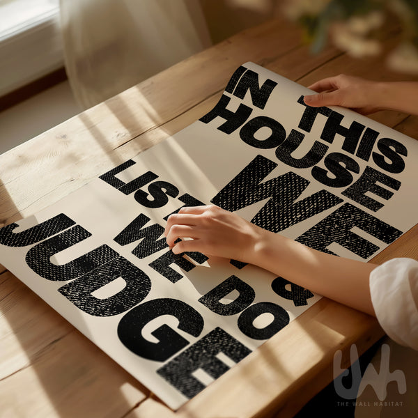 Person unrolling a humorous modern poster on a wooden table with natural light