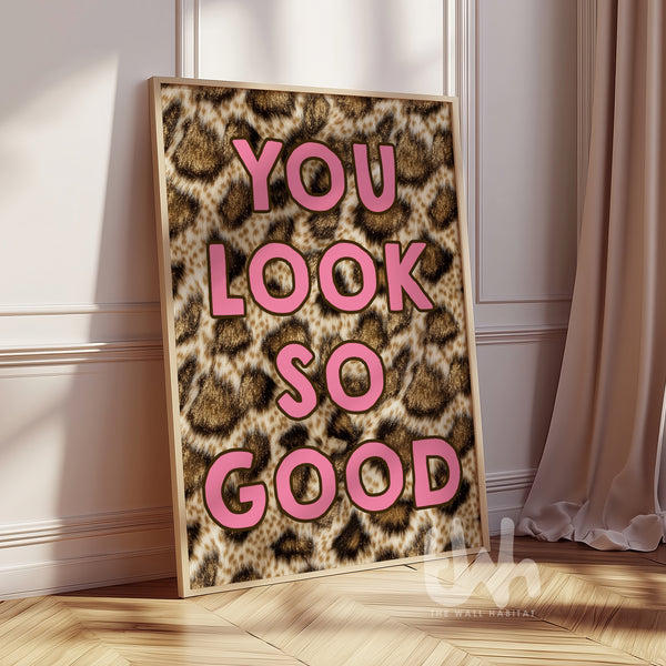 You Look So Good leopard print wall art with pink typography displayed in a gold frame in a modern interior