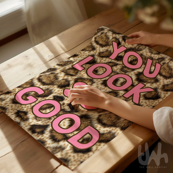 You Look So Good leopard print wall art with pink typography displayed in a gold frame in a modern interior
