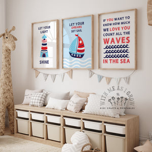 Three framed nautical-themed nursery wall art prints hang above a light wood storage bench with white bins in a styled children's room. The prints feature a lighthouse, a sailboat, and a motivational quote about waves, with a giraffe figure on the left