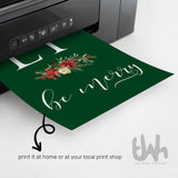 Forest green Family Eat Drink and Be Merry Christmas print shown emerging from a home printer.