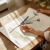 Hands unrolling a beige neutral botanical print on a wooden table – minimalist wall art for calm interiors