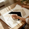 Person holding a chevron geometric wall decor poster on a wooden table