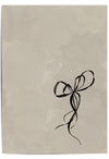 Flat-lay of a beige and black minimalist bow print – elegant wall art for soft neutral interiors