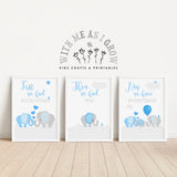 Three framed personalized baby elephant nursery prints displayed on a light wood floor against a white wall, with a matching wall decal above. The prints feature blue and gray elephants with text reading 'First we had EACH OTHER', 'Then we had YOU', and 'Now we have EVERYTHING'.