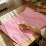 Hand unrolling a pink motivational art print with “Suck it up bitch” and “You’ve got this” text.