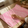 Hand unrolling a pink motivational art print with “Suck it up bitch” and “You’ve got this” text.