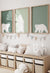 Set of three framed sage green polar bear wall art prints hanging above a toy storage bench in a neutral kids’ room