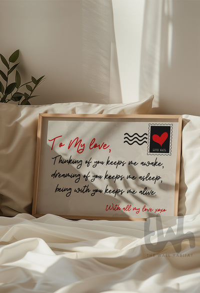 Framed love quote wall art print styled on a cozy cream bed with natural light – romantic bedroom décor idea