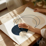 Person holding a piece of paper with abstract design on a wooden table