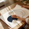 Person holding a piece of paper with abstract design on a wooden table