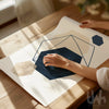 Person holding a geometric design paper on a wooden table