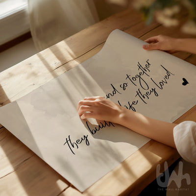 Close-up of romantic neutral wall print saying “And so together they built a life they loved” on soft beige background