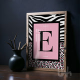 Personalised pink leopard initial wall art with zebra print border displayed in a modern interior setting