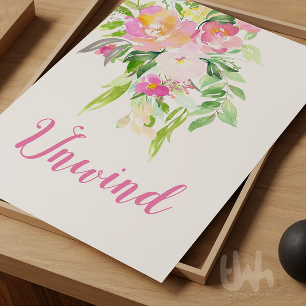 Floral design with the word 'Unwind' on a wooden surface