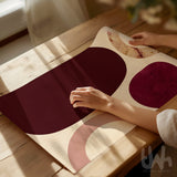 Burgundy abstract artwork being prepared for framing on a wooden table