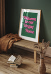 Bold wall art print with pink retro-style text reading 'Welcome to Our Happy Home' on a green background – perfect for cheerful home décor